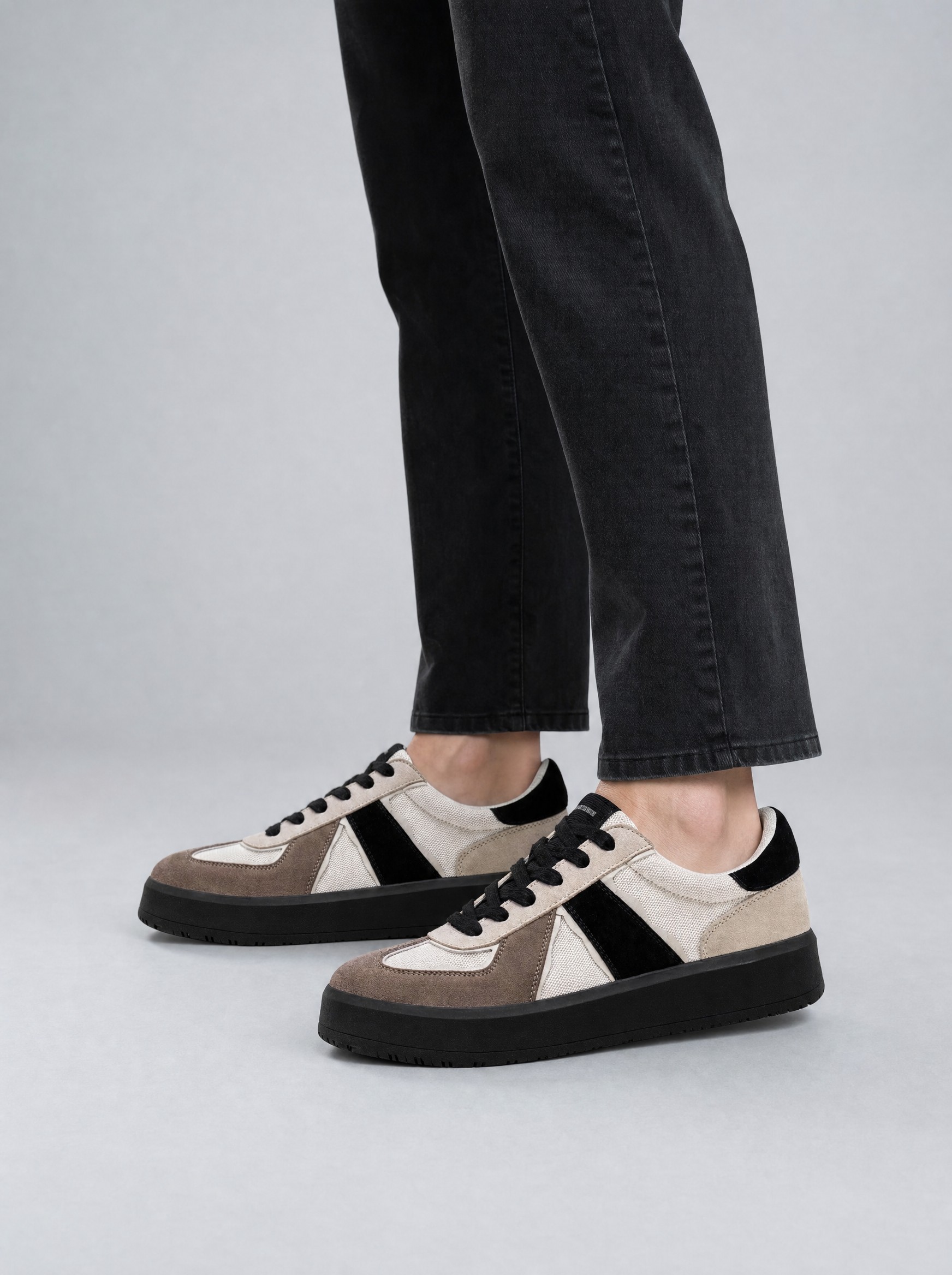 Two-Tone Army Trainer in taupe and black, AI-rendered on the house model from the product photo